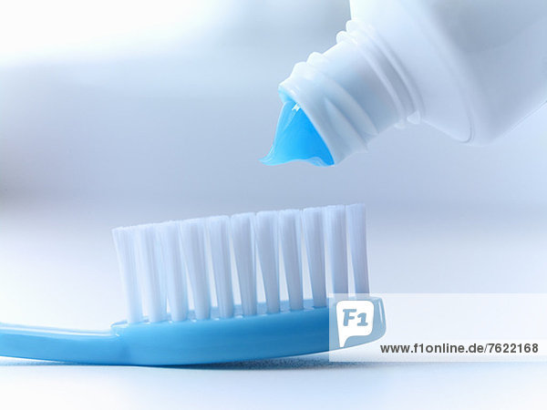 Close up of toothpaste squeezing on toothbrush