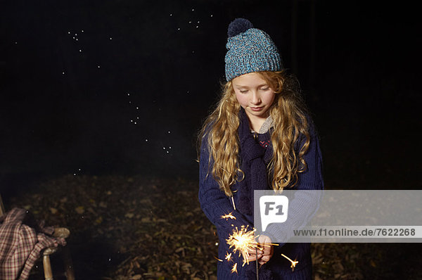 Mädchen beim Spielen mit Wunderkerzen im Freien