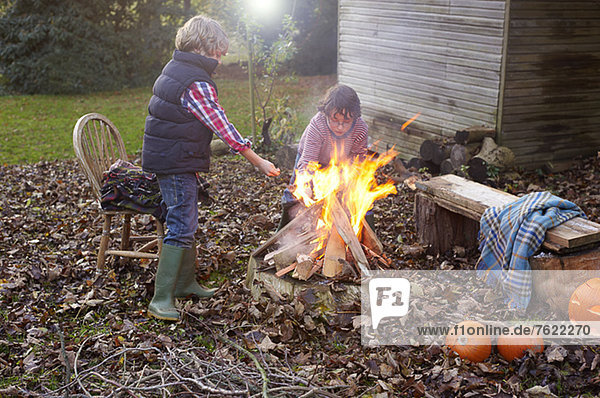 Kinder bauen Lagerfeuer im Freien