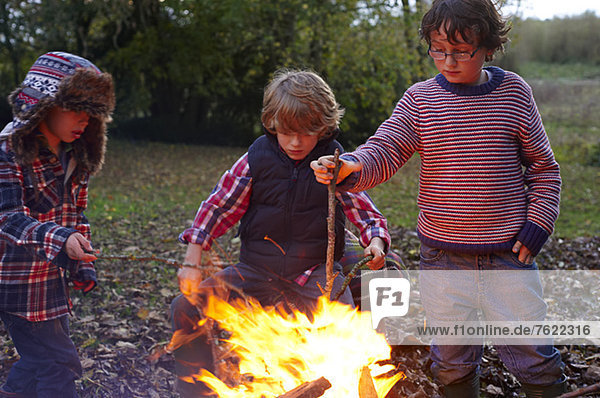 Jungen bauen Lagerfeuer im Freien