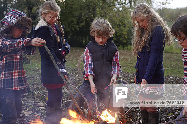 Kinder beim Lagerfeuer im Freien