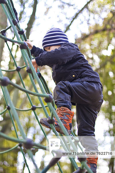 Kleinkind klettert auf einem Spielplatz