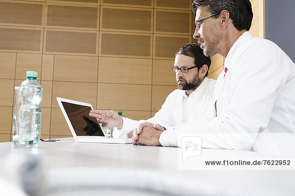 Doctors using laptop at desk