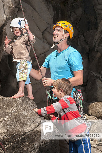 Man teaching children to rock climb