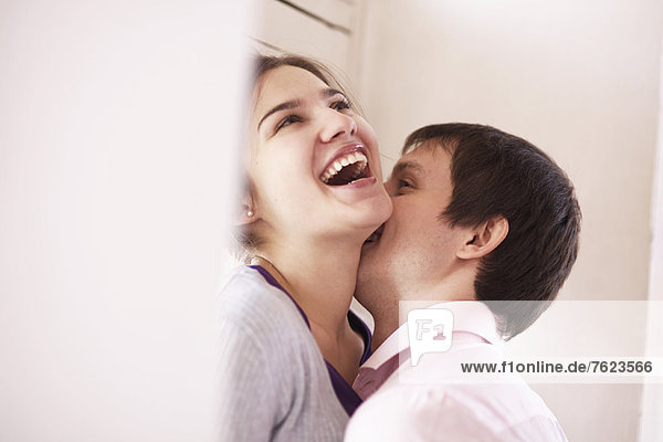 Mann küsst Freundin drinnen