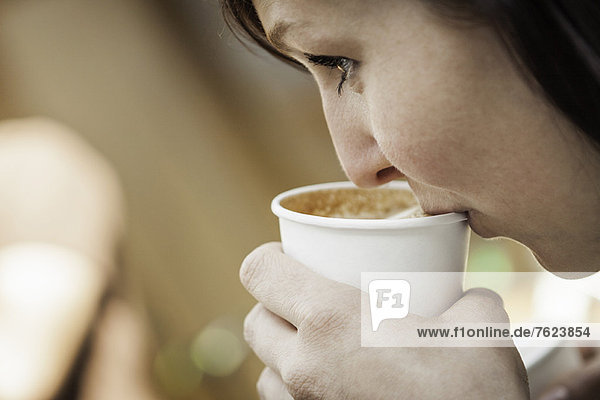 Nahaufnahme einer Frau  die eine Tasse Kaffee trinkt.