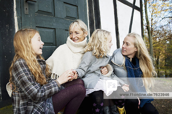 Mother and daughters sitting outdoors