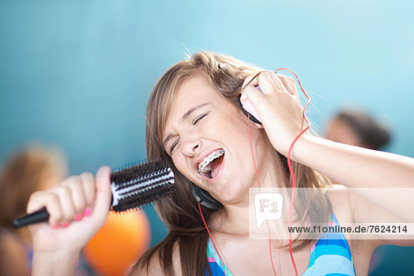 Teenage girl singing into hairbrush