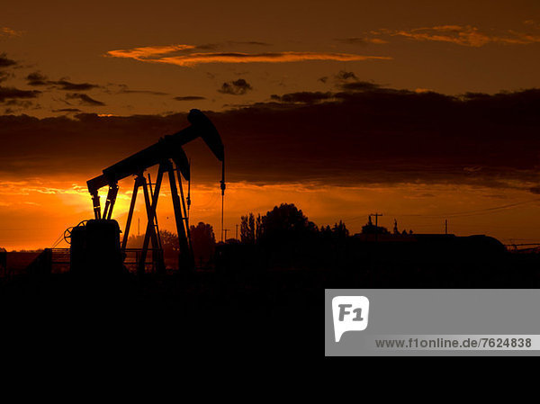 Silhouette der Ölquelle bei Sonnenuntergang