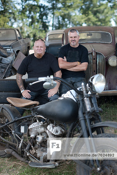 Männer sitzend mit Motorrad