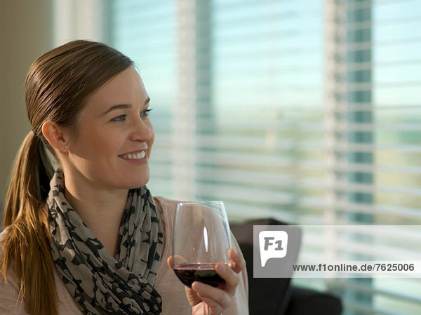 Lächelnde Frau bei einem Glas Wein