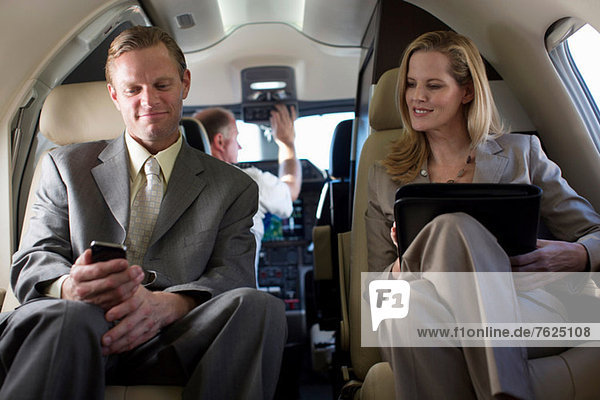 Business people talking in airplane