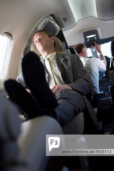 Geschäftsmann entspannt im Flugzeug