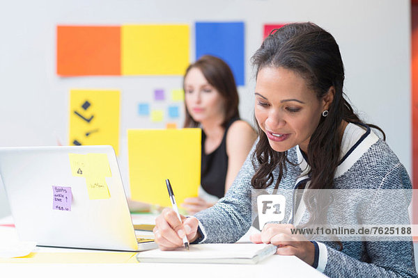 Businesswoman taking notes at desk