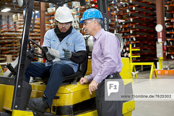 Worker and businessman in metal plant