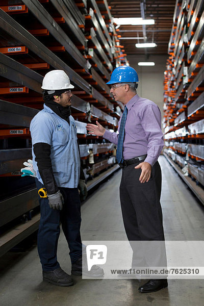 Worker and businessman in metal plant