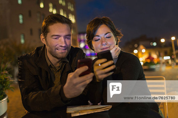 Couple using cell phones outdoors