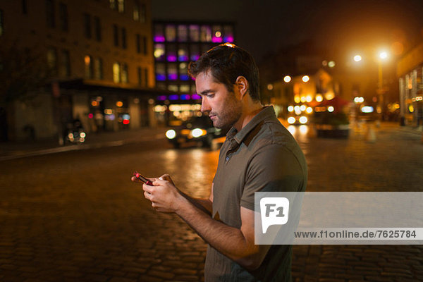 Mann mit Handy auf der Stadtstraße