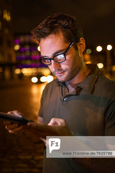 Mann mit Tablet-Computer auf der Stadtstraße