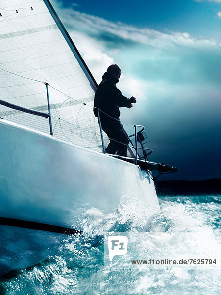 Mann Trimmen Segel auf der Yacht im Rennen