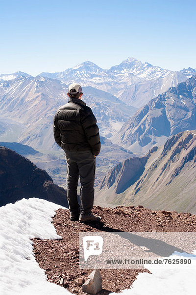 Hiker overlooking snowy mountains