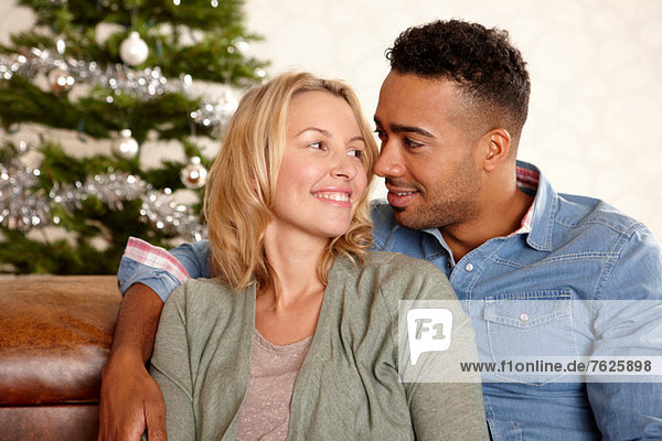 Couple smiling together on sofa