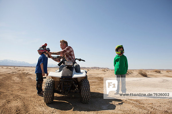 Father and sons on four-wheeler