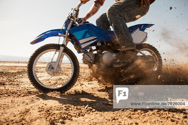 Man riding dirt bike in desert