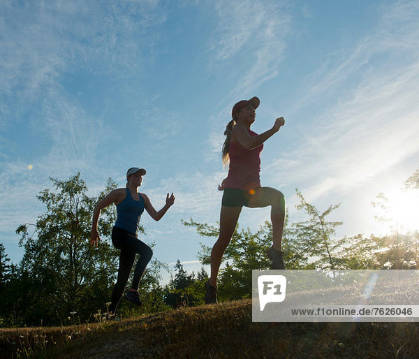 Teenage girls running together in field