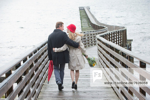 Couple walking on wooden dock