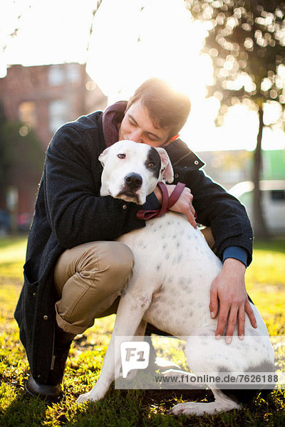 Mann umarmender Hund im Park