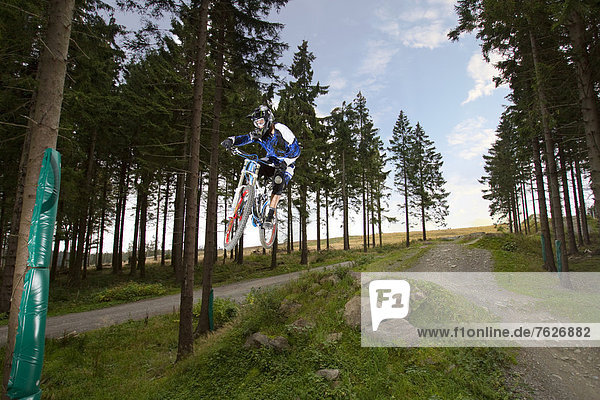 Man midair on downhill mountain bike  Willingen  Germany