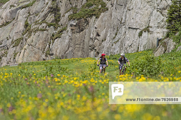 Two mountain bikers on mountain pass road  Andermatt  Switzerland