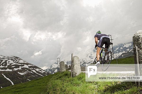Racing cyclist on mountain pass road  Andermatt  Switzerland