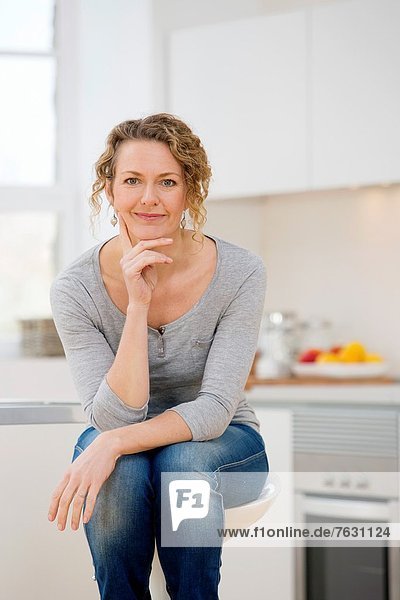 Independent young woman sitting her kitchen