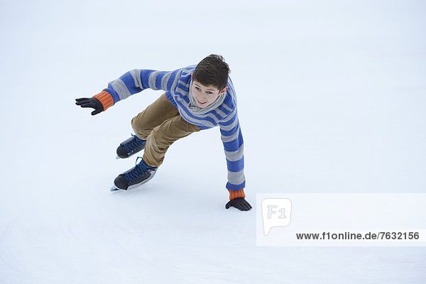 Junge läuft Schlittschuh auf einem gefrorenen See