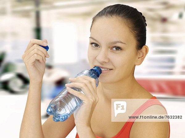 Woman holding a water bottle in a fitness studio