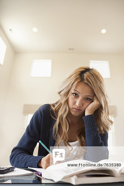 Anxious mixed race woman studying