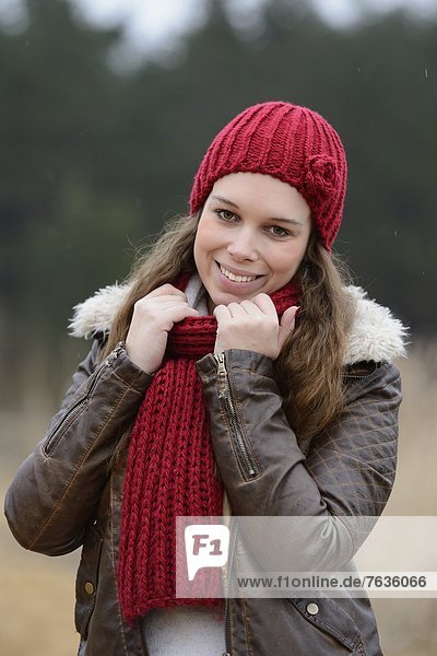 Lächelnde junge Frau mit Mütze und Schal  Porträt