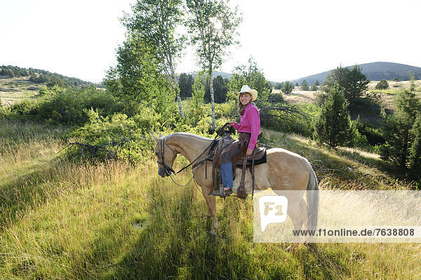 Vereinigte Staaten von Amerika  USA  Gegenlicht  Frau  Amerika  Baum  Hügel  Hut  reiten - Pferd  Wiese  Außenaufnahme  Mädchen  Cowgirl  Oregon