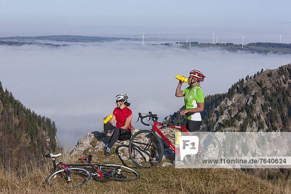 Windturbine Windrad Windräder Frau Sport Fahrradfahrer Fahrrad Rad Ende Nebel Herbst Windenergie Pause einstellen Fahrrad fahren Nebelmeer