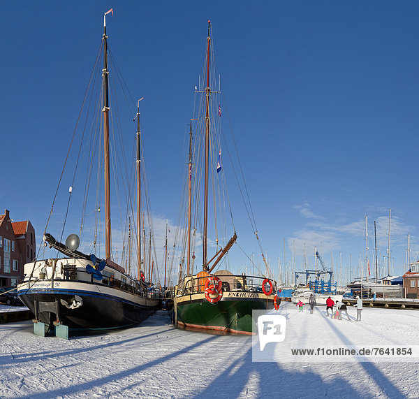 Holland  Netherlands  Europe  Monnickendam  Port  frozen  skaters  city  village  water  winter  snow  ice  people  ships  boat  skating