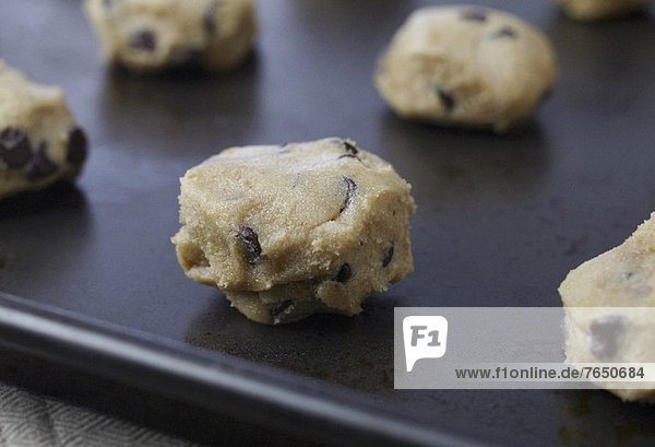 Unbaked Balls of Chocolate Chip Cookie Dough on a Pan Ready to be Baked
