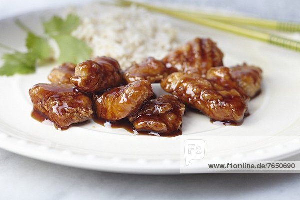 'Sweet and Sour Chicken with White Rice on a White Plate