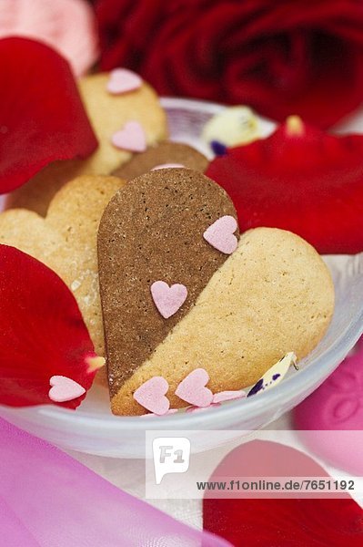 Vanille-Schokoladen-Herzplätzchen mit Zuckerherzen und Rosenblättern