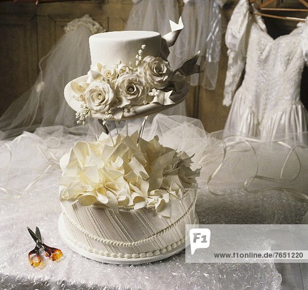 White Hat Wedding Cake with a Wedding Dress in the Background