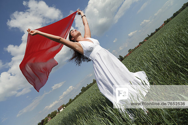 Kornfeld junge Frau junge Frauen Sommer Wind Schal grün halten weiß rot Ansicht Kleidung Flattern Schrägansicht schräg Kleid Seide