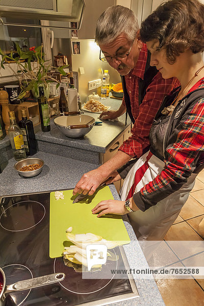 Grandfather  60 +  and granddaughter  14 years  cooking together  Laupheim  Baden-Wuerttemberg  Germany  Europe