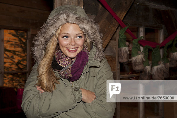 stehend  Hütte  überqueren  Frau  lächeln  grün  frontal  Weihnachten  Dekoration  wandern  Anorak  jung  Kleidung