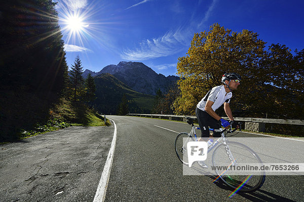 Cyclist riding along the Obersalzbergstrasse  Hoher Goell Mountain  Berchtesgaden  Upper Bavaria  Bavaria  Germany  Europe